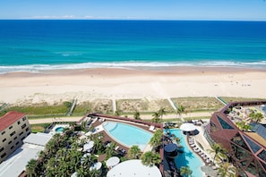 Een resort met een zwembad, toegang tot het strand en uitzicht op de oceaan.