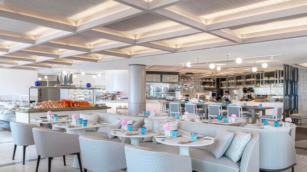 A modern restaurant with a high ceiling, seating areas, and a visible kitchen. - Jewel Stunning Ocean Views 2 Bed Apartment (Surfers Paradise)