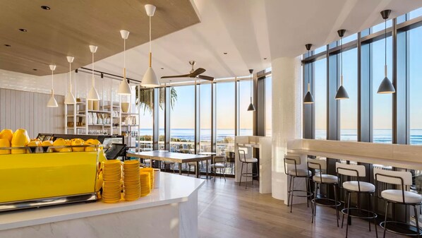 Een moderne keuken met een bar, grote ramen en uitzicht op de oceaan.