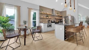 A modern kitchen with a central island, bar stools, and pendant lighting. - Beautifully decorated and spacious home with a pool. (Rex)