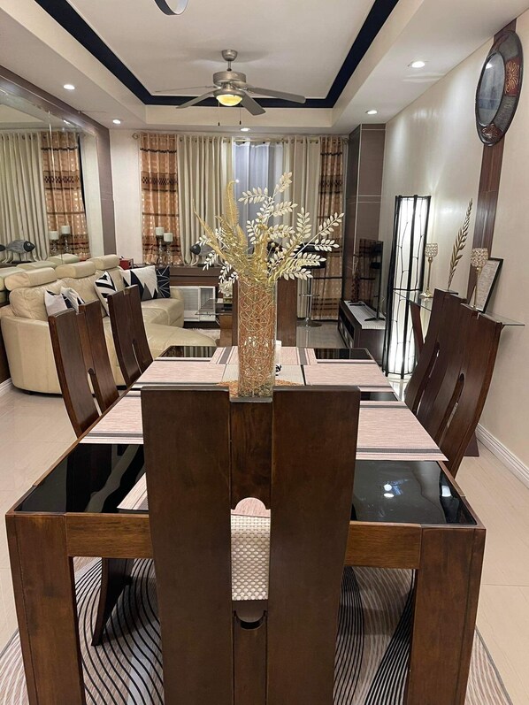 A dining area with a long table, chairs, and a decorative vase.