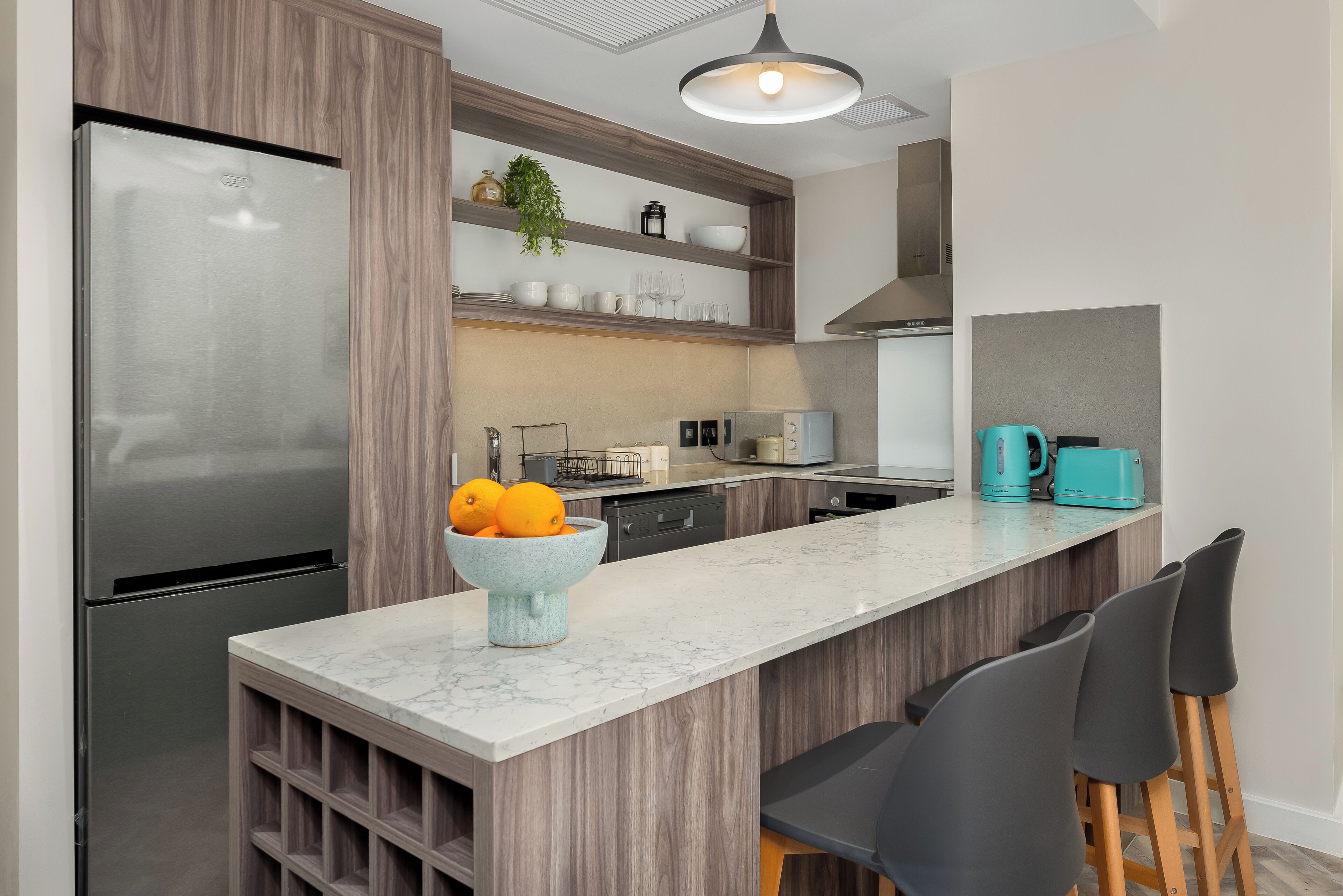 A modern kitchen with a built-in island, stainless steel appliances, and a marble countertop.