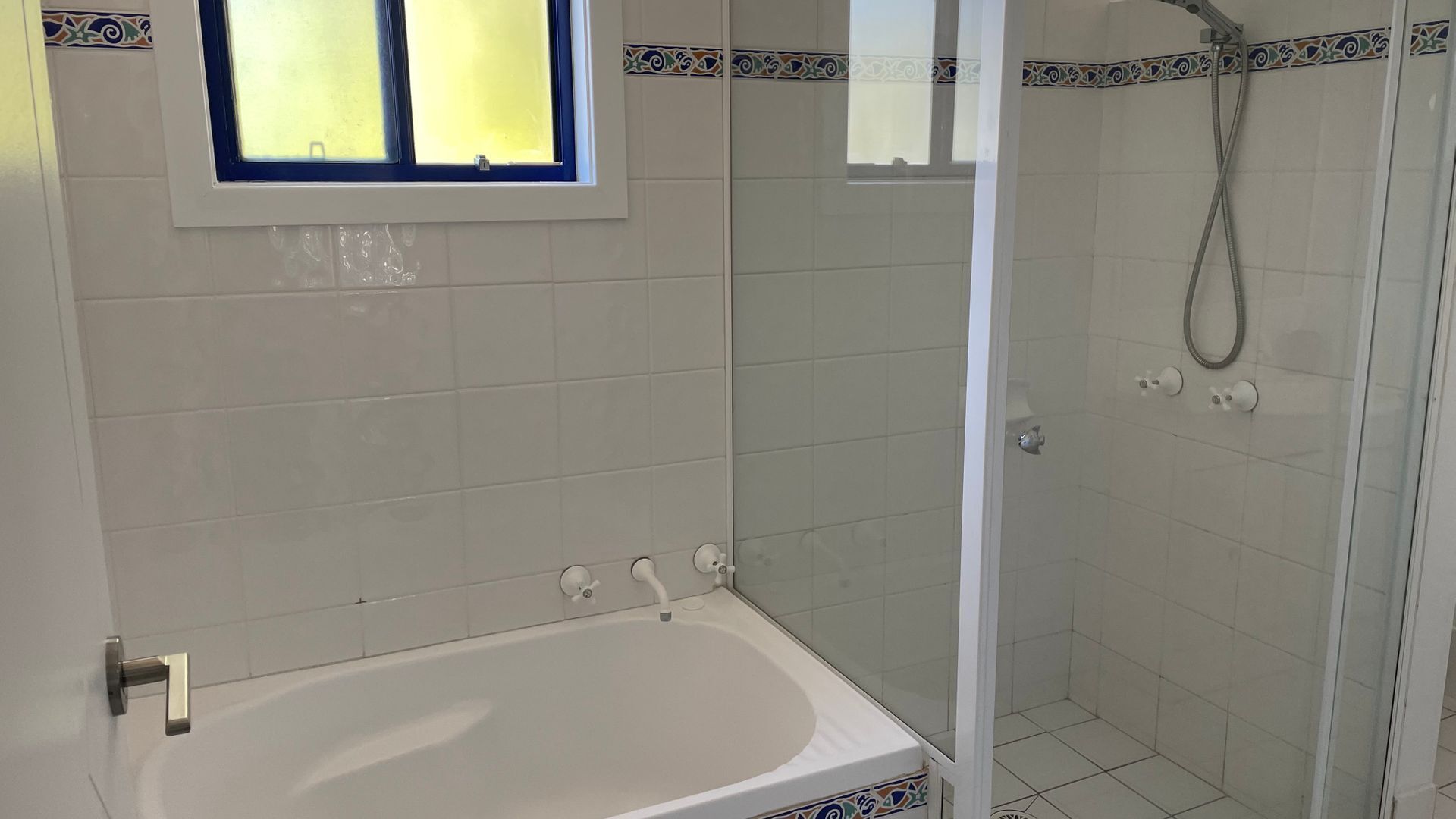 Ein Badezimmer mit einer Badewanne, einer Dusche und einem Fenster.