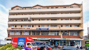 A multi-story building with a flat roof and a sign for a Landlords and Tenants Association. - Mang Hotel (Nairobi)