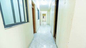 A corridor with a tiled floor and doors on both sides. - Mang Hotel (Nairobi)
