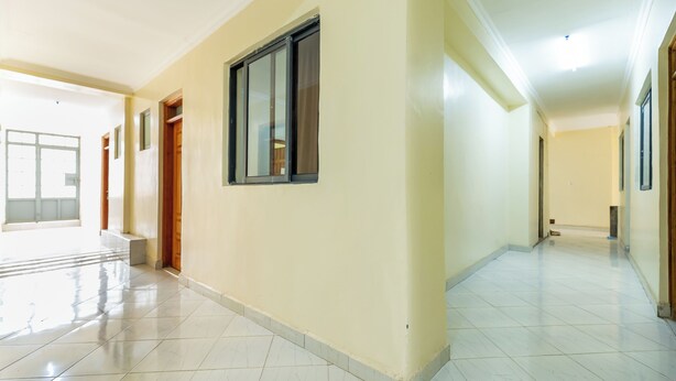 A spacious, well-lit hallway with tiled floors and a large window. - Mang Hotel (Nairobi)