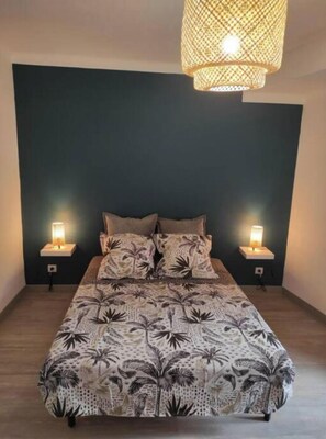 Quarto com cama, duas luminárias de apoio e um lustre.