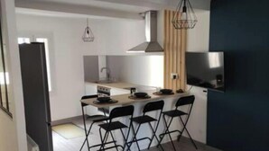 A modern living room with a black coffee table, a grey sofa, and a dining area with four chairs. - Village house with exterior (Lambesc)