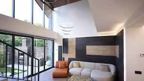 A modern living room with a staircase, a sofa, and a coffee table. - Epoca (Tsaghkadzor)