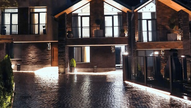 A modern two-story house with a stone facade, large windows, and a paved courtyard. - Epoca (Tsaghkadzor)