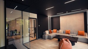 A modern living room with a sectional sofa, a coffee table, and a bean bag. - Epoca (Tsaghkadzor)