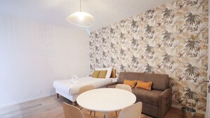 Une pièce comprenant un lit, un canapé, une table ronde et des chaises.