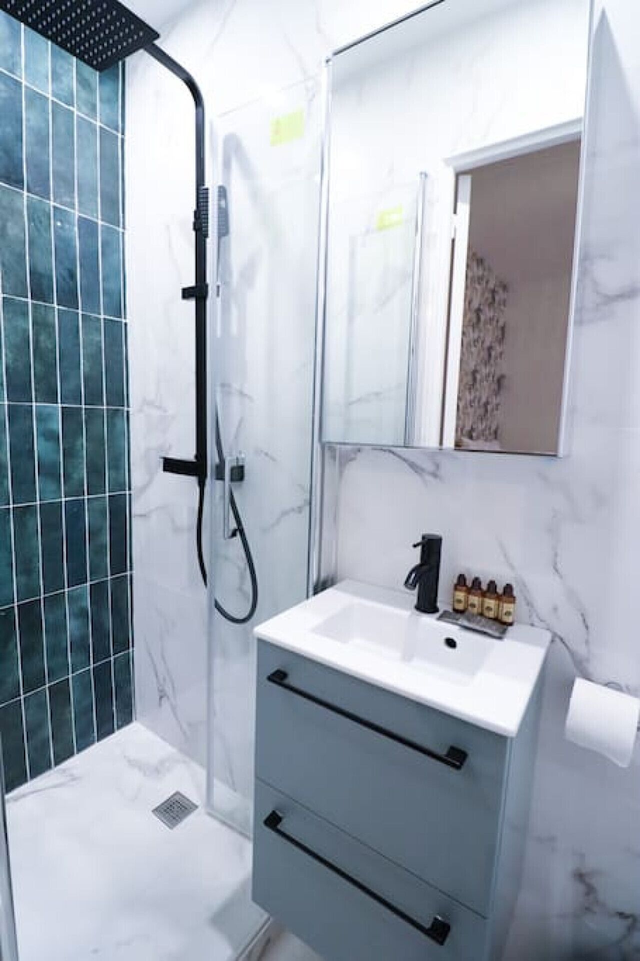 A modern bathroom with a shower, a sink, and a mirror.