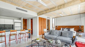 A modern living room with a grey sofa, red chairs, a coffee table, and a patterned rug. - Stylish - Large Loft With Pool (Cancún)