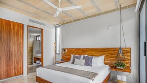 A modern bedroom with a wooden bed frame, a ceiling fan, and a hanging plant. - Stylish - Large Loft With Pool (Cancún)