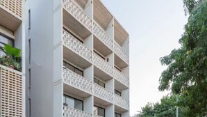 A multi-story building with balconies, a flat facade, and a gated entrance. - Fabulous Loft With Pool (Cancún)