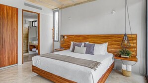 A modern bedroom with a large bed, wooden headboard, and a ceiling fan.