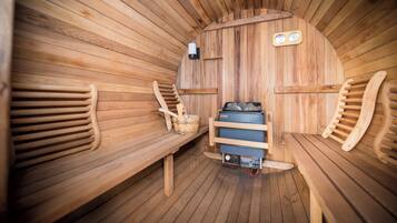 Una sauna con bancos de madera, un calentador y un panel de control.