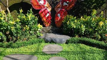 A garden pathway leading to a butterfly sculpture at Kemenah Butterfly Park.