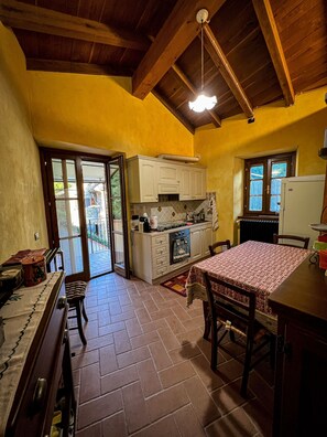 A kitchen with wooden cabinets, a stove, and a dining table with chairs.