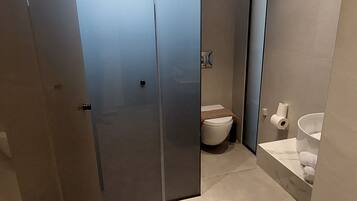 A modern bathroom with a toilet, sink, and shower area.