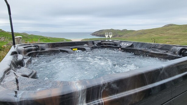 Un jacuzzi con vistas al mar y a las colinas.