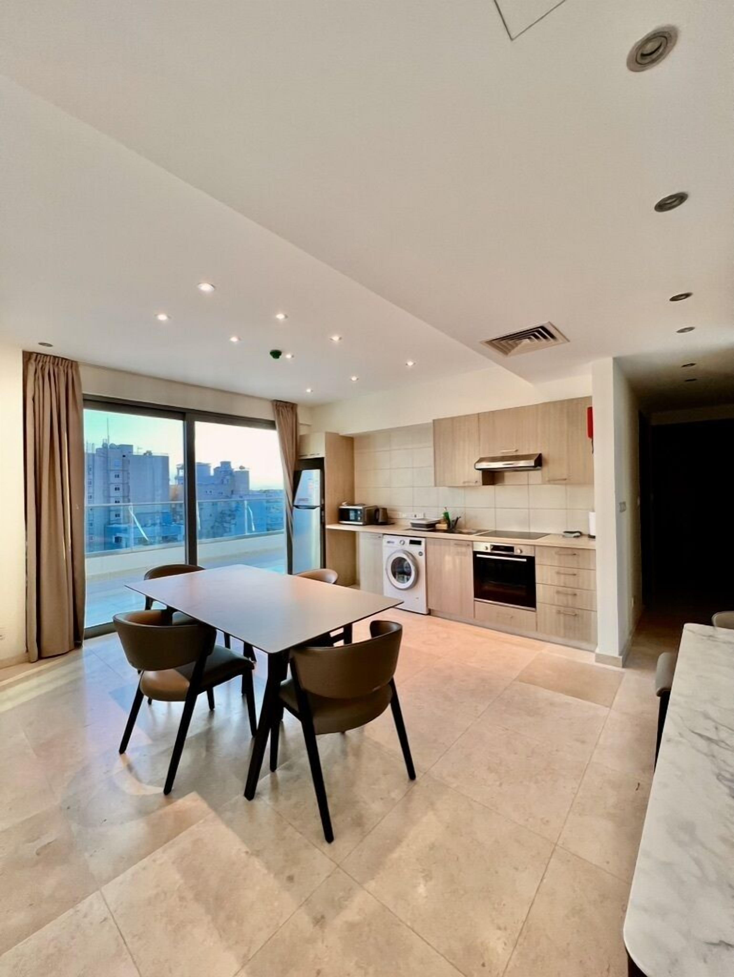 Una cocina moderna con comedor, ventanas amplias y vista a la ciudad.