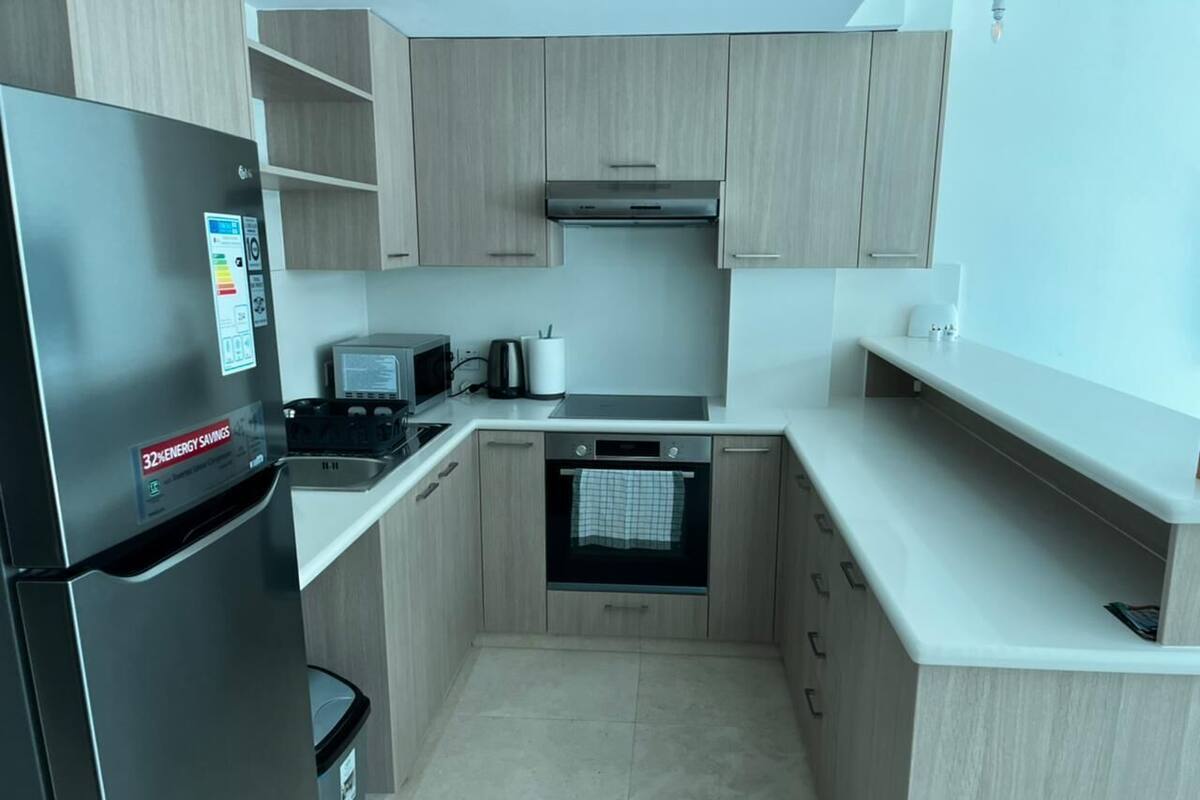 A compact kitchen with a refrigerator, microwave, stove, and oven.