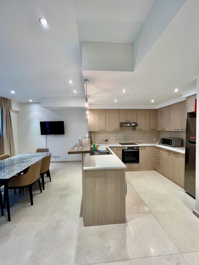 Cocina moderna con comedor, televisor de pantalla plana y horno empotrado.