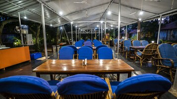 Un restaurante interior con mesas, sillas, una barra y ventiladores de techo.