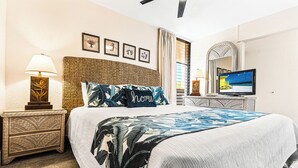 Ein Hotelzimmer mit einem großen Bett, einem Fernseher und einem Nachttisch mit einer Lampe.