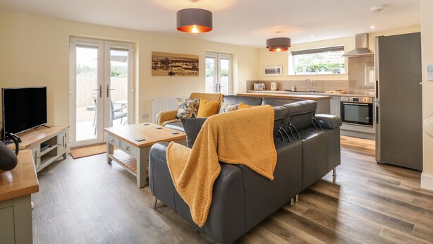 A modern apartment with a living room, kitchen, and dining area. - Tawny's Roost (King's Lynn)