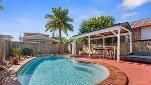 A backyard with a swimming pool, a covered patio, and a wooden fence. - "Kitesurfer" - Scarborough Q 4020 (Scarborough)
