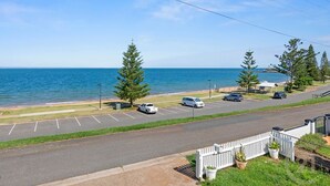 A coastal road with a parking lot, a white fence, and a view of the sea. - "Kitesurfer" - Scarborough Q 4020 (Scarborough)