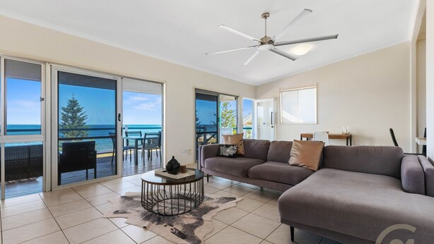 A spacious living room with a grey sofa, a coffee table, and a view of the ocean through large sliding doors. - "Kitesurfer" - Scarborough Q 4020 (Scarborough)