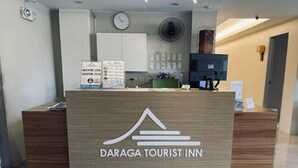 A reception desk at Daraga Tourist Inn with a wooden finish and a logo. - Daraga Tourist Inn (Daraga)