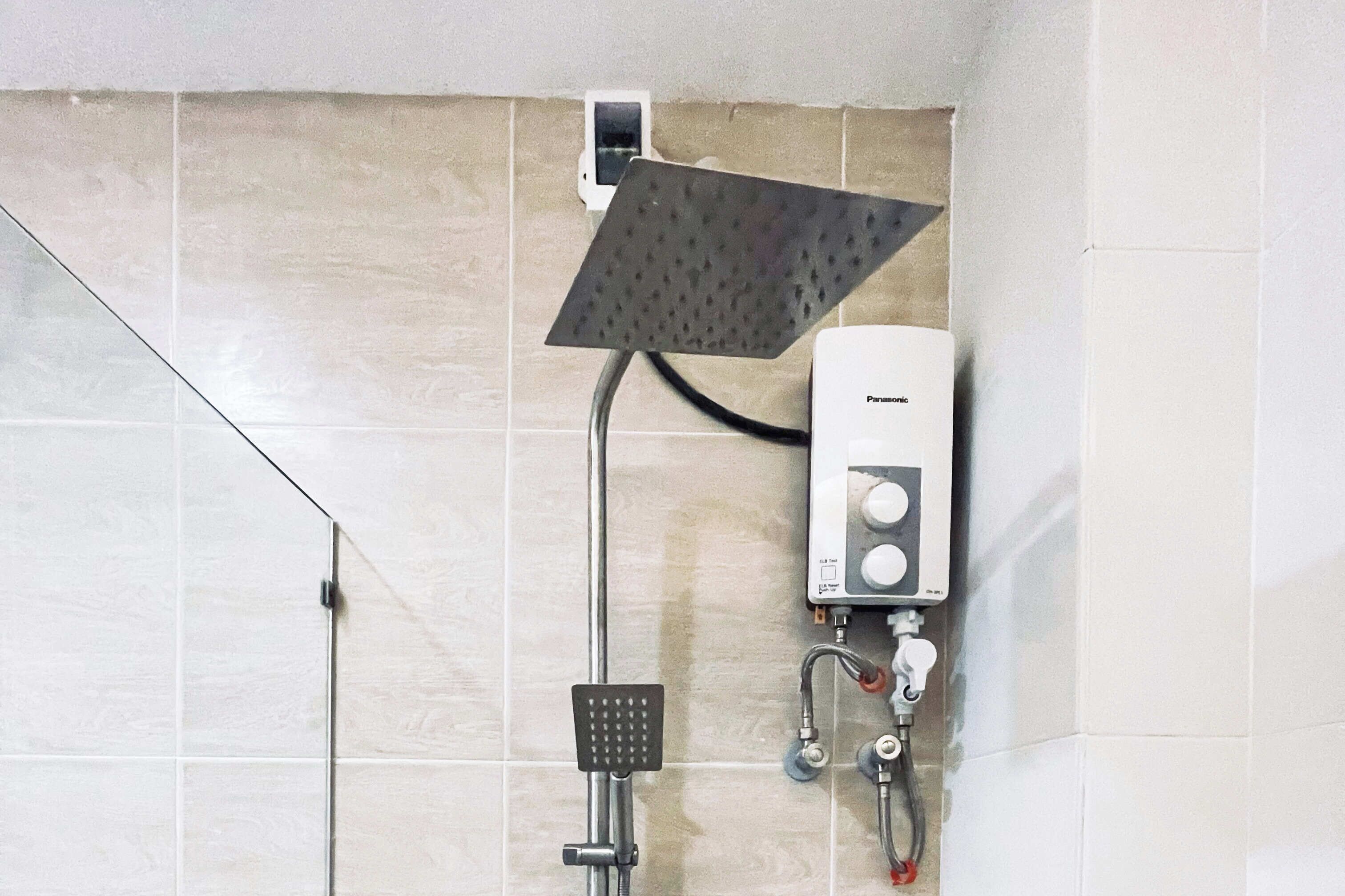 Eine Dusche mit Handbrause und einer fest installierten Bedienungseinheit.