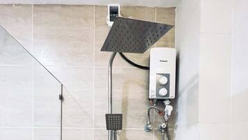Eine Dusche mit Handbrause und einer fest installierten Bedienungseinheit.