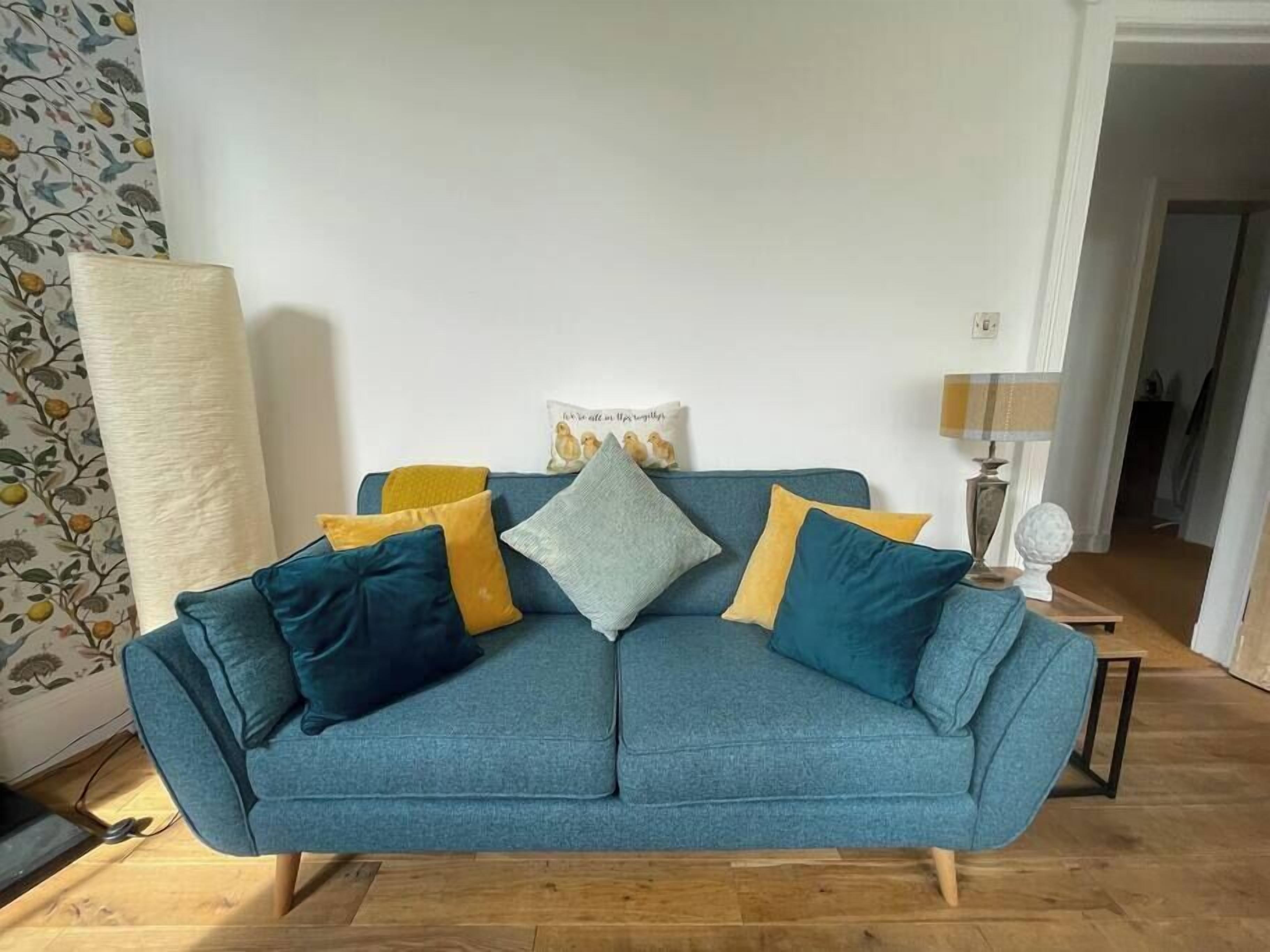 A blue sofa with multiple cushions in a living room.