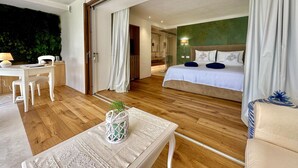 A hotel room with a bed, a desk, and a chair. There is a view of a bathroom and a green wall. - Villa in Porto Rotondo with 7 bedrooms sleeps 14 (Porto Rotondo)