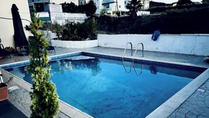 A rectangular swimming pool with a metal ladder on one side, surrounded by a tiled patio. - Impeccable 3-bed Villa in Nicosia (Agia Varvara)