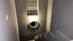 A narrow stairway with a small window and a round mirror on the wall. - Impeccable 3-bed Villa in Nicosia (Agia Varvara)