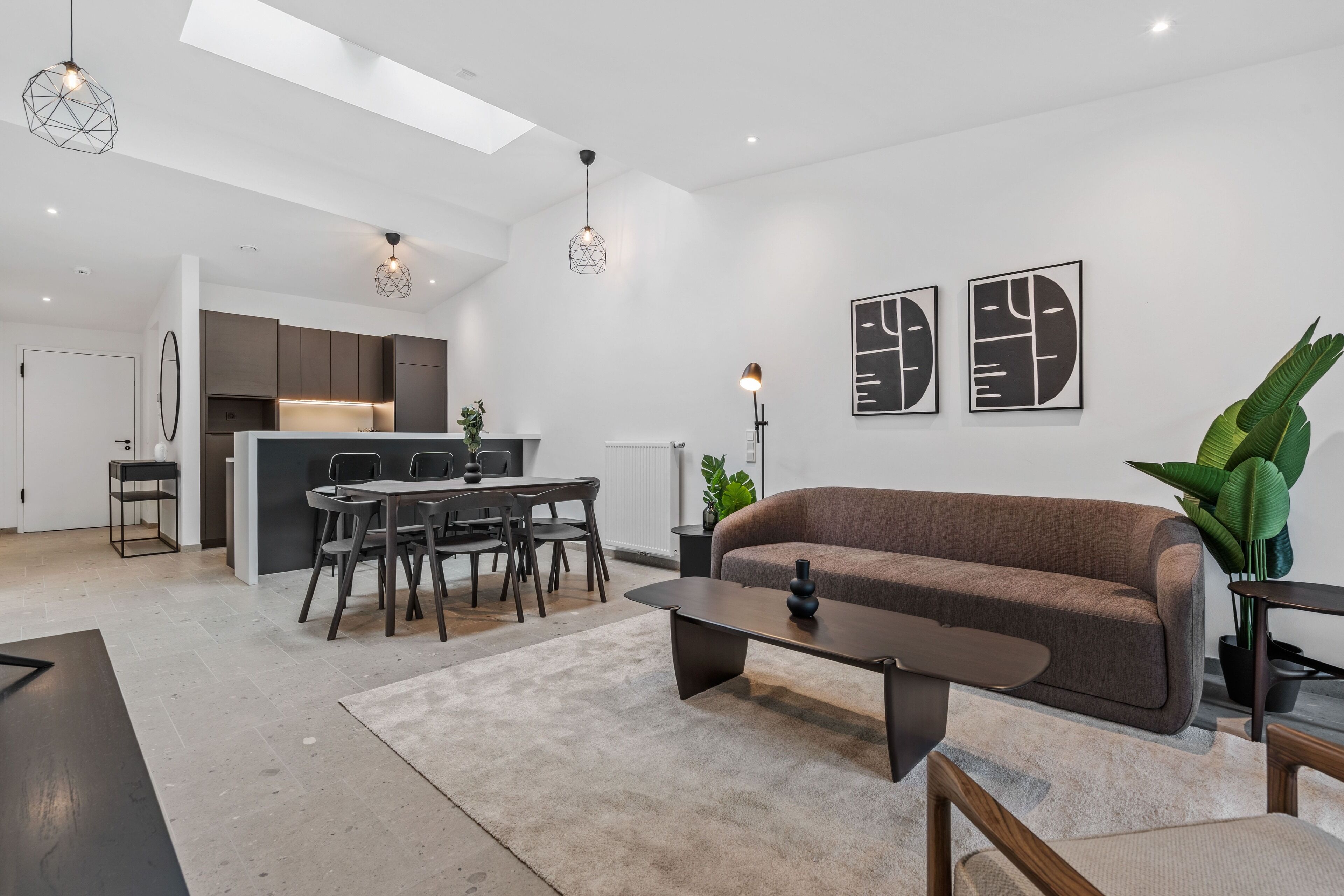 Un salon moderne avec un canapé, une table basse et un coin repas.