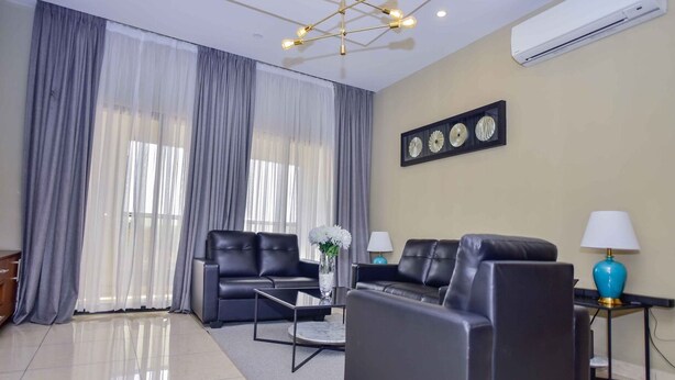 A modern living room with a sofa set, a coffee table, and a lamp. - Robyson Residency Kinshasa (Kinshasa)