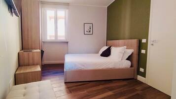 Una camera da letto con un letto, un comodino, una finestra e una porta.