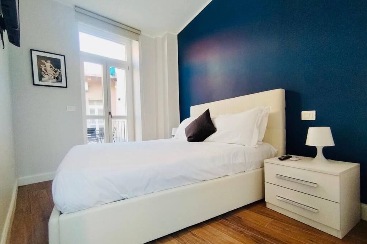 A bedroom with a bed, bedside table, and a nightstand.