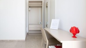 Una habitación moderna con escritorio, silla y vestidor.