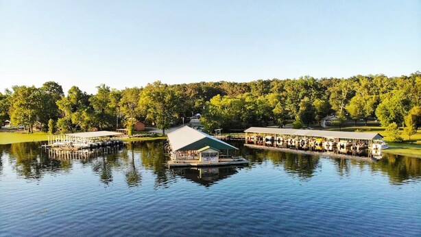 Un molo sul lago con una zona relax riparata e una barca.