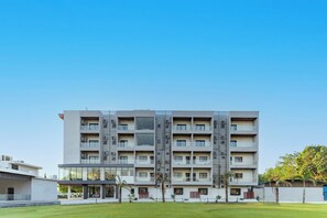 Un edificio de varios pisos con un diseño arquitectónico moderno, que presenta balcones y grandes ventanales.