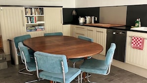 Un coin repas avec une table en bois et six chaises bleues.